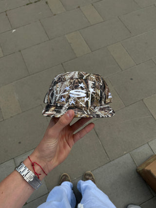 Gorra Camo 5 Panel Cap SALPI, diseño camuflado con cinco paneles, logo bordado en el frente, visera plana, estilo urbano y casual