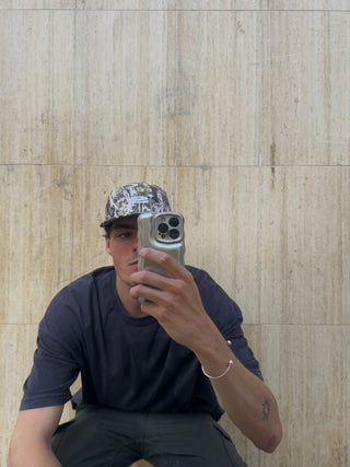 Modelo usando la gorra Camo 5 Panel Cap SALPI, vista de cuerpo completo con estilo casual y urbano, perfecto para un look relajado