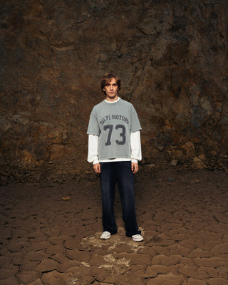 Modelo usando la camiseta Salpi Motors SALPI, vista de cuerpo completo con pantalones y estilo casual inspirado en el automovilismo